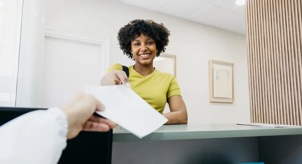 A smiling patient checking in at the Molina Endodontics front desk