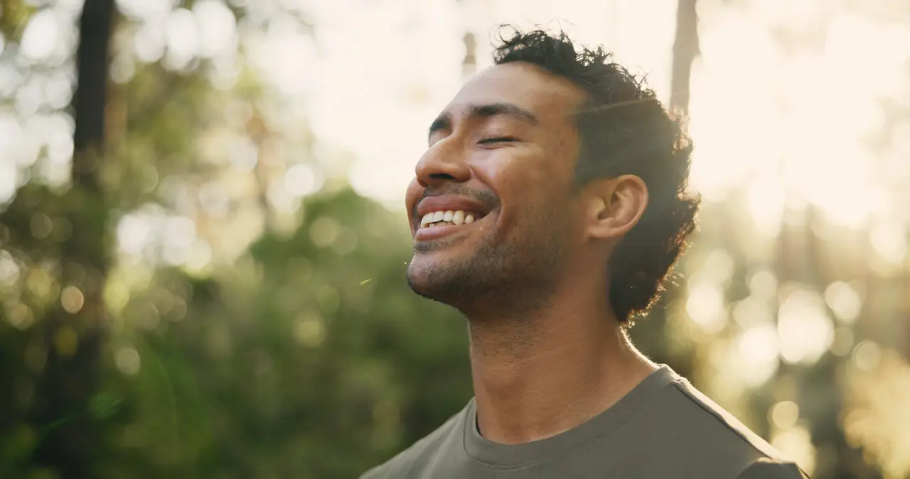 A relaxed, smiling patient enjoying peace of mind outdoors